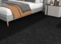 FunStick 12x12 peel and stick carpet tiles with black textured surface installed as bedroom flooring
