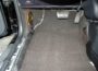 HushMat Silencer Shop Roll 1/4 sound deadening foam installed under a car floor carpet in the driver footwell