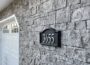 Capital Sky NonRated Flat Stone Veneer in Phantom Shadow, gray mortarless stone wall beside garage.