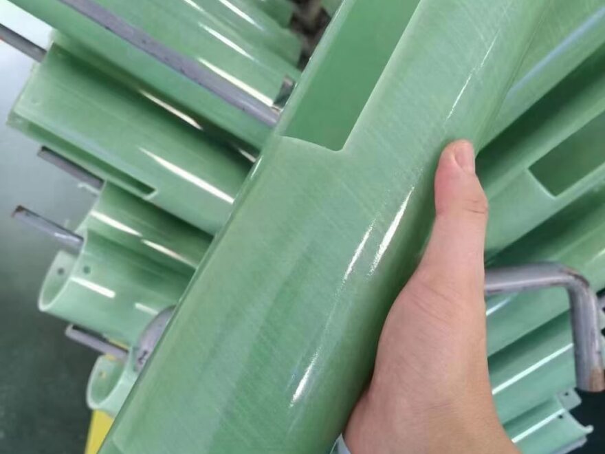 FR4 epoxy sheet for electrical insulation, green glossy rigid panel with cutouts held among stacked sheets