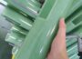 FR4 epoxy sheet for electrical insulation, green glossy rigid panel with cutouts held among stacked sheets